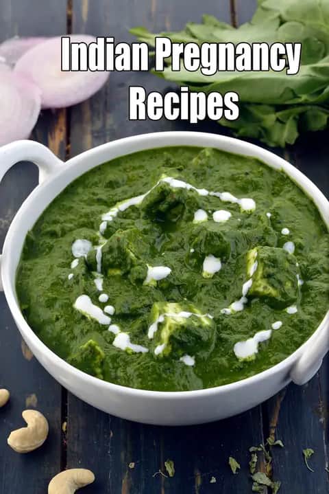 palak paneer served in a white bowl, made with fresh spinach gravy and paneer cubes, garnished with cream, placed on a rustic wooden surface with spinach leaves and onion in the background.