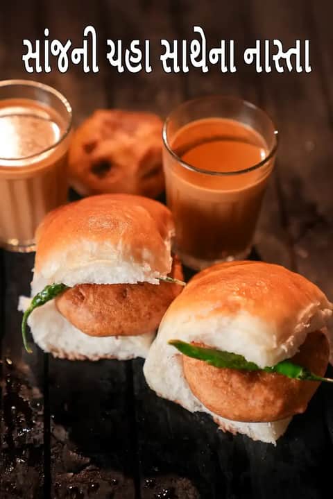 લાકડાની ટેબલ પર વડા પાવ અને ગરમ ચાના બે ગ્લાસ સાથે સાંજના ટી ટાઈમ નાસ્તા