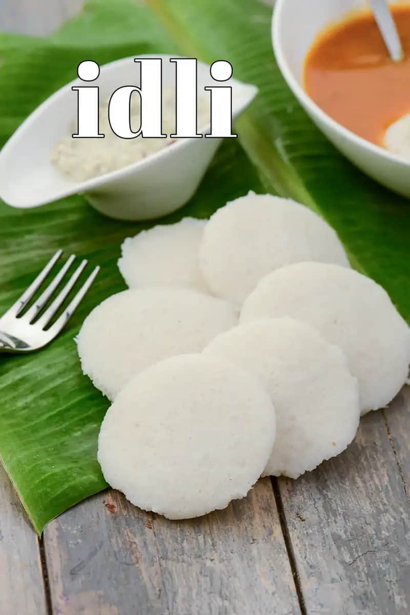 Soft and fluffy South Indian idli served on a banana leaf with coconut chutney and sambar