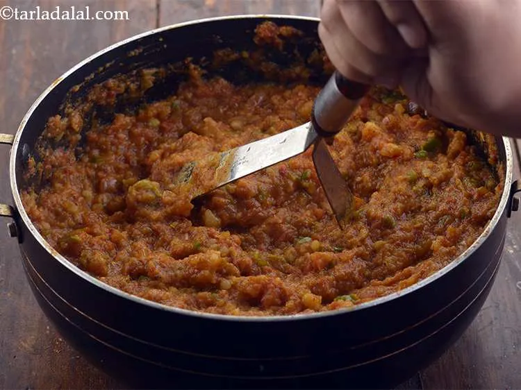 Step 19 – <p>Mash the contents with the help of a potato masher so that the tomatoes release …