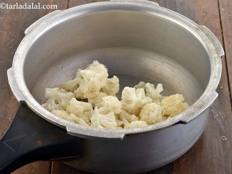 Step 3 – <p>For the <strong>Bhaji to make Pav Bhaji</strong>, take a pressure cooker and add the cauliflower …