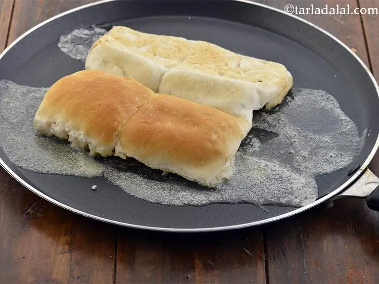 Step 26 – <p>Place the slit open pavs on the hot tava.</p>