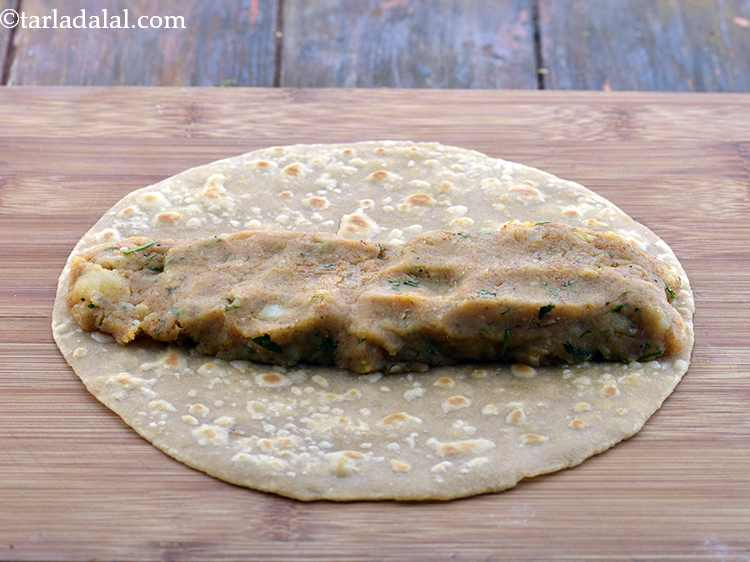 Step 25 – <p>In the centre of the roti, spread ¼ th of the potato stuffing in a …