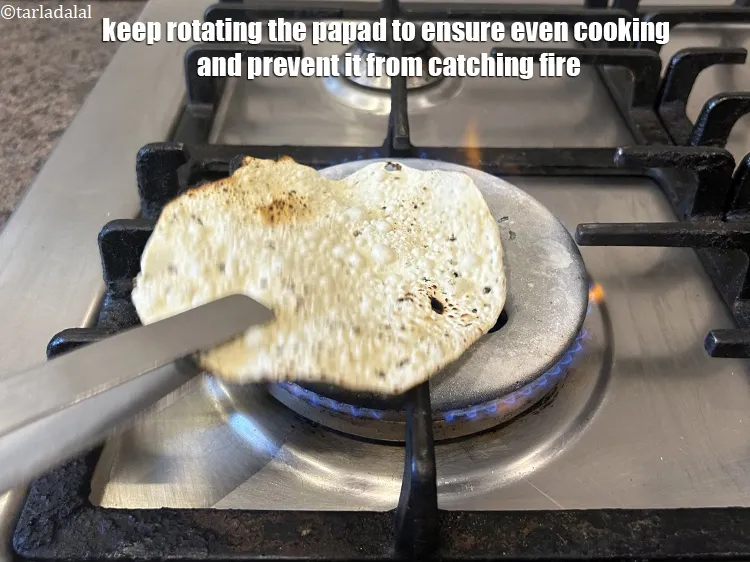 Step 11 – Keep rotating the papad to ensure even cooking and prevent it from catching fire.