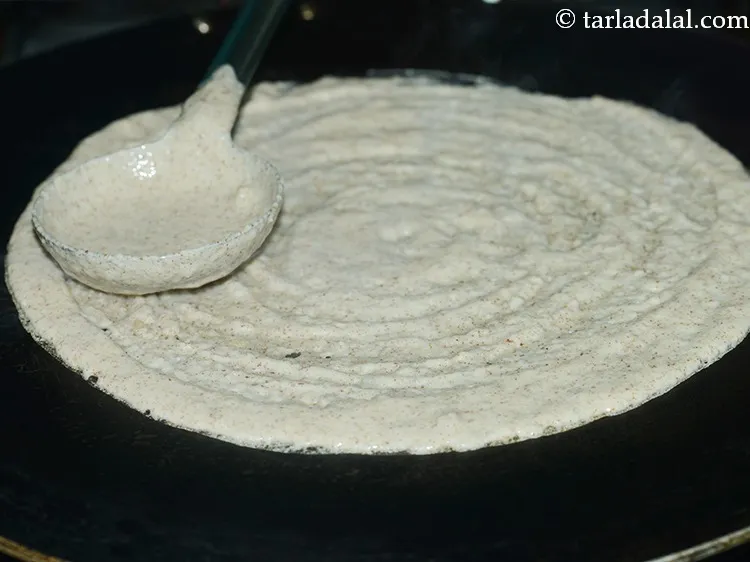 Step 28 – Pour a ladleful of the batter on it. Spread it in a circular motion to …