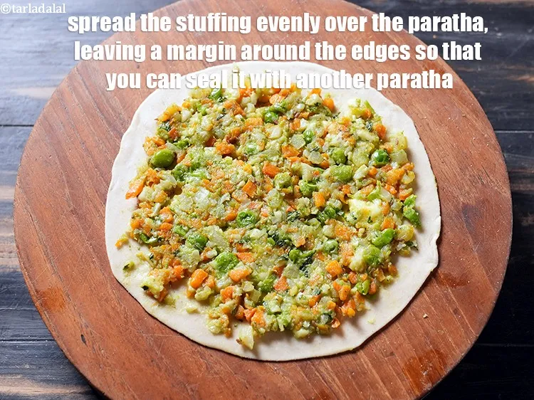 Step 37 – Spread the stuffing evenly over the paratha, leaving a margin around the edges so that …
