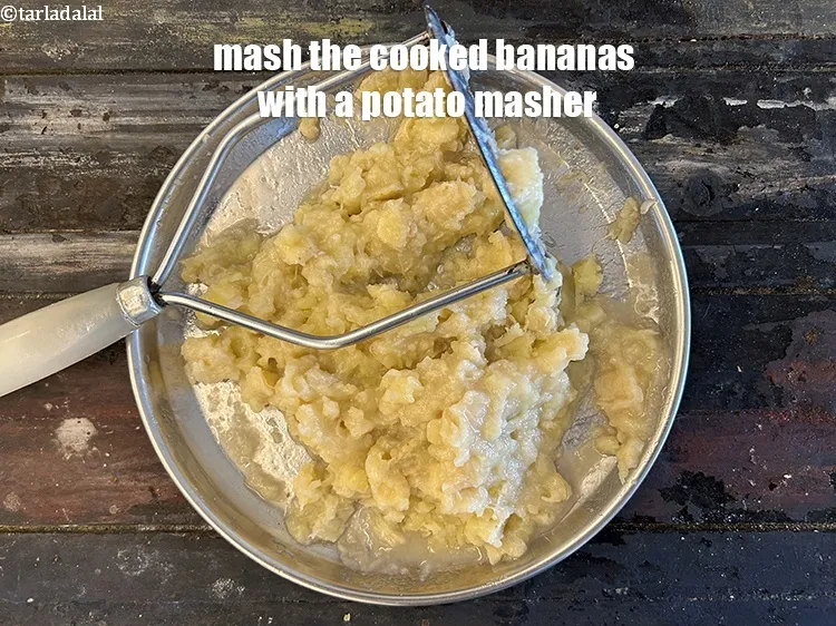 Step 14 – <meta charset="UTF-8" />Mash the cooked raw bananas with a potato masher.&nbsp;&nbsp;<br /> &nbsp;