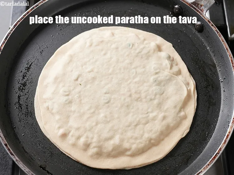 Step 41 – Place the uncooked paratha on the tava.