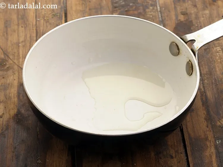 Step 2 – To make <strong>achari dip</strong> mixture, heat oil in a small non stick pan.&nbsp;