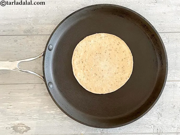 Step 19 – Place the rolled roti on the tava and cook for 10 to 15 seconds.