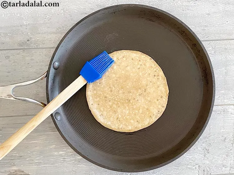 Step 21 – Apply ghee on the roti with a brush.