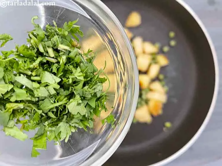 स्टेप 13 – १ टेबल-स्पून बारीक <a href=""https://www.tarladalal.com/glossary-chopped-green-chilli-hindi-820i"">कटा हुआ हरा धनिया</a> डालें।