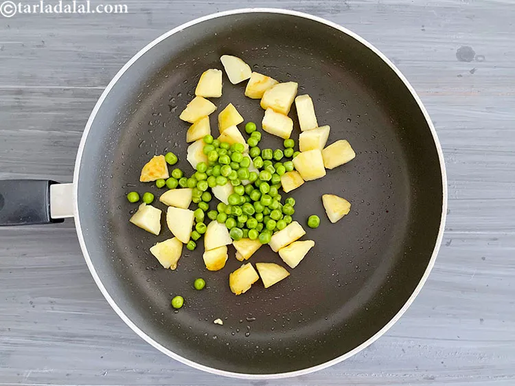 स्टेप 6 – १/४ कप <a href=""https://www.tarladalal.com/glossary-boiled-green-peas-hindi-1078i"">उबले हुए हरे मटर</a> डालें।