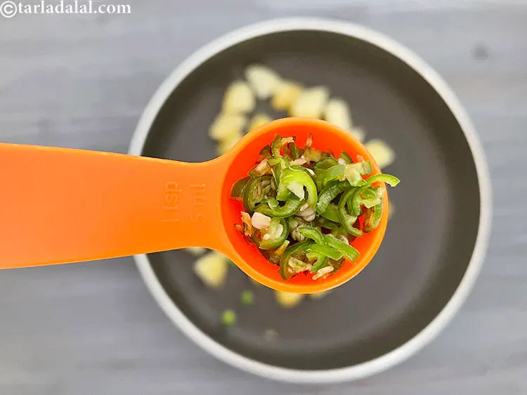 स्टेप 7 – १ टी-स्पून बारीक <a href=""https://www.tarladalal.com/glossary-chopped-green-chilli-hindi-820i"">कटी हुई हरी मिर्च</a> डालें।