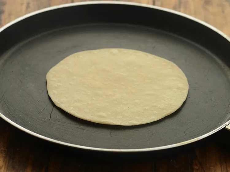 Step 9 – <p>To semi-cook the roti, heat a non-stick tava (griddle) and place the roti.</p>