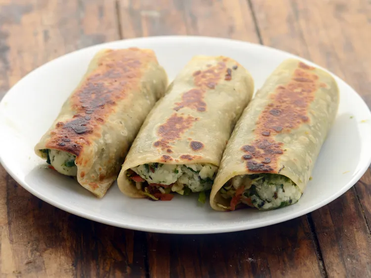 Step 39 – <p>Remove the potato paneer Kathi roll on a dry chopping board.</p>