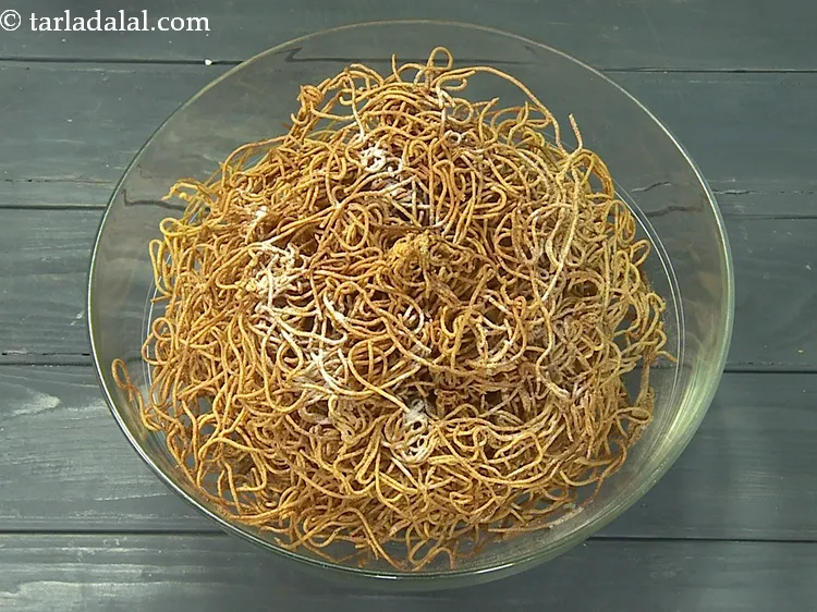 Step 49 – While the sev is yet warm, add 1/2 tsp&nbsp;<a href="https://www.tarladalal.com/glossary-black-salt-sanchal-kala-namak-422i">black salt (sanchal)</a>.