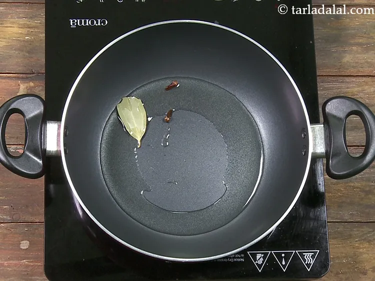 Step 47 – Add 2&nbsp;<a href="https://www.tarladalal.com/glossary-cloves-322i">cloves (laung / lavang)</a>.