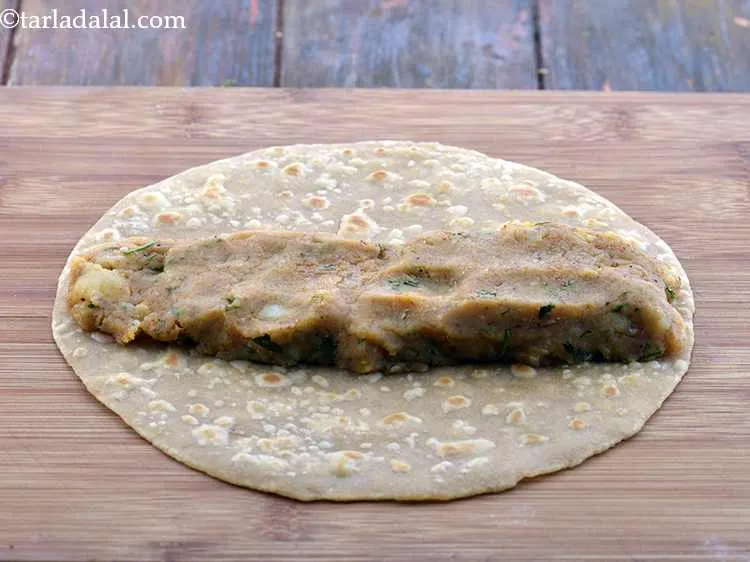 स्टेप 26 – रोटी के केंद्र में, आलू की स्टफिंग को एक लाईन …