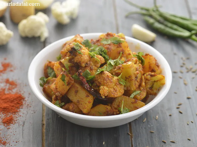 Step 23 – Garnish the <strong>aloo gobhi ki sabji</strong> with a sprig of coriander and serve hot with …