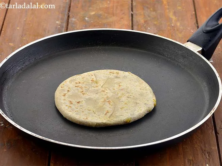 Step 31 – Cook on one side till light brown spots appear and then flip the paratha over.