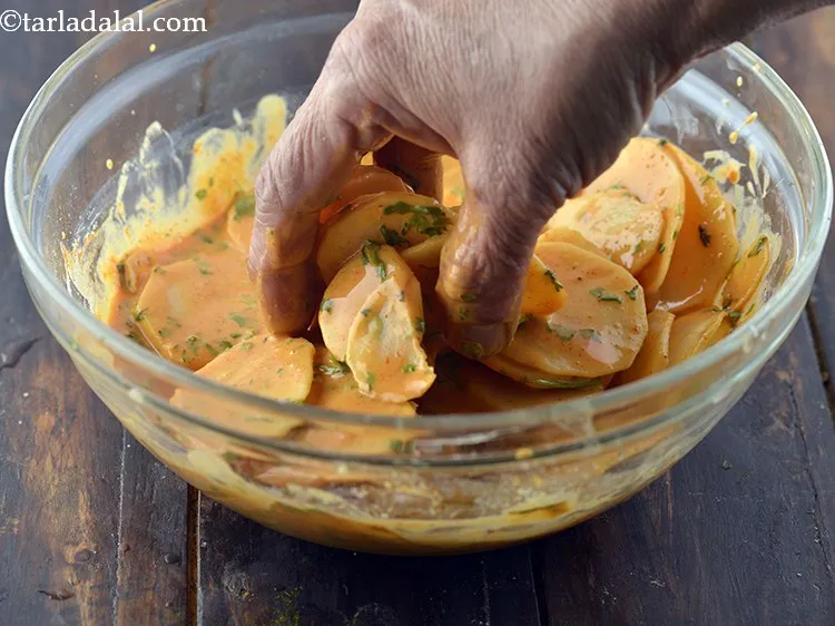 Step 19 – Dip a few potato slices in the prepared batter and coat nicely with the prepared …