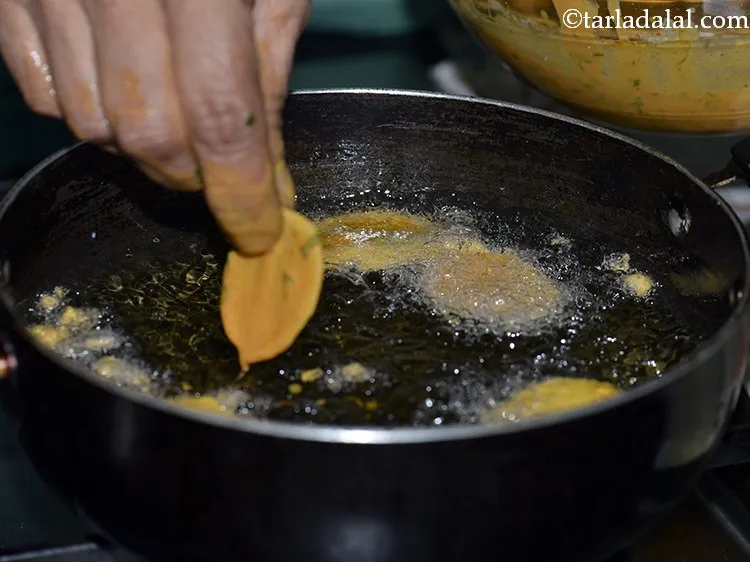 स्टेप 19 – धीरे से गरम तेल में घोल से लेपित आलू की …