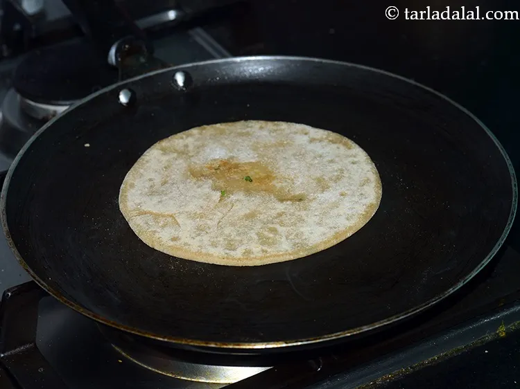Step 23 – <p>When lightly cooked, flip the paratha.</p>