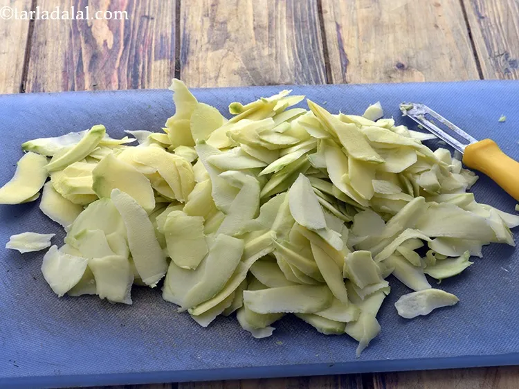 Step 4 – Using the same peeler, peel the mangoes into thin strips or chips. It is very …