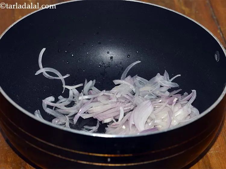 Step 14 – Heat the oil in a deep non-stick pan and add the sliced onions.