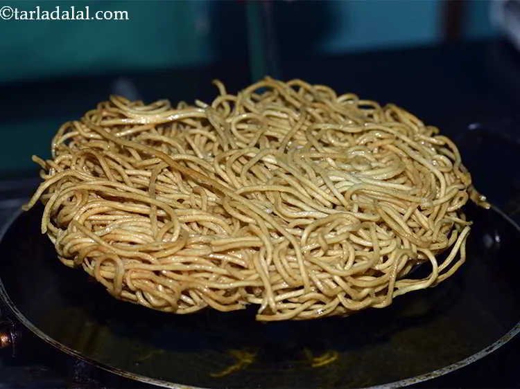 Step 11 – Once the bottom layer is golden brown turn over the noodles and fry them on …
