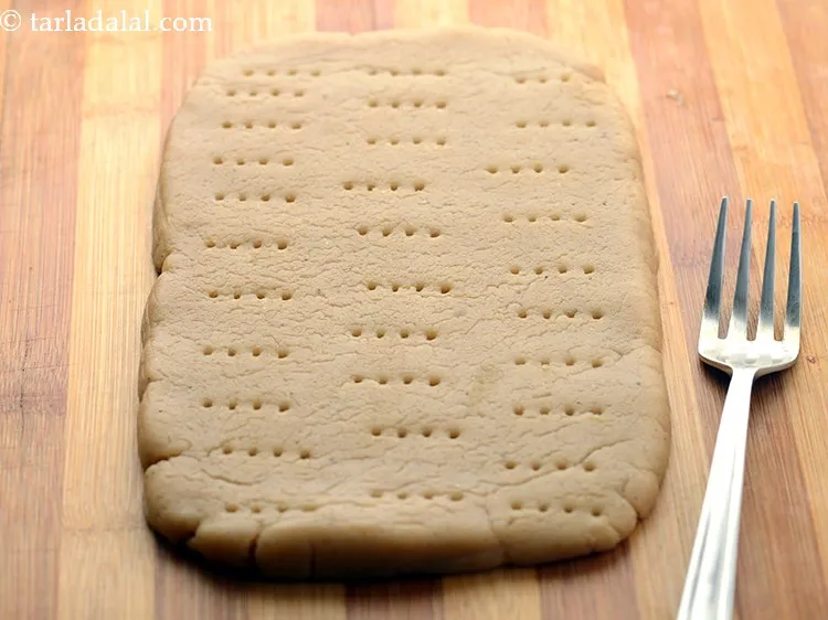 Step 14 – Prick using a fork so, the biscuit does not fluff up while baking.