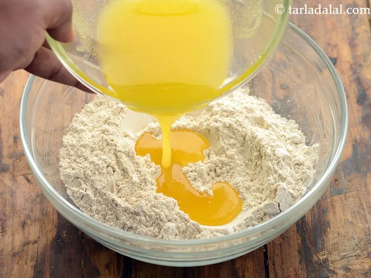 Step 9 – Add the above ghee- sugar mixture to the dry ingredients mixture.