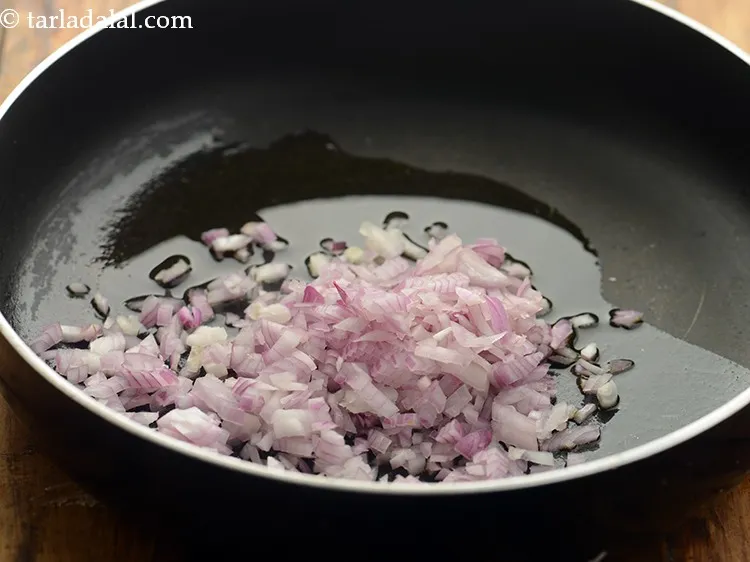 स्टेप 10 – तेल गरम होने पर प्याज़ डालें।