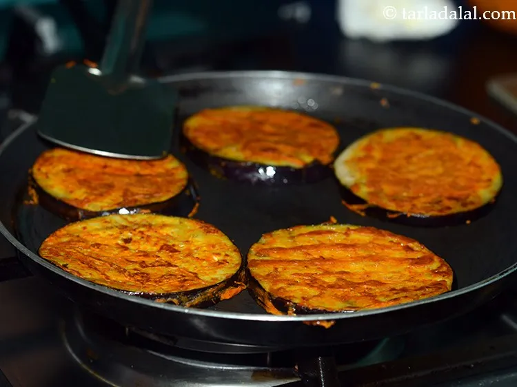 Step 13 – Cook the <strong>begun bhaja</strong> on both the sides till golden brown in colour.