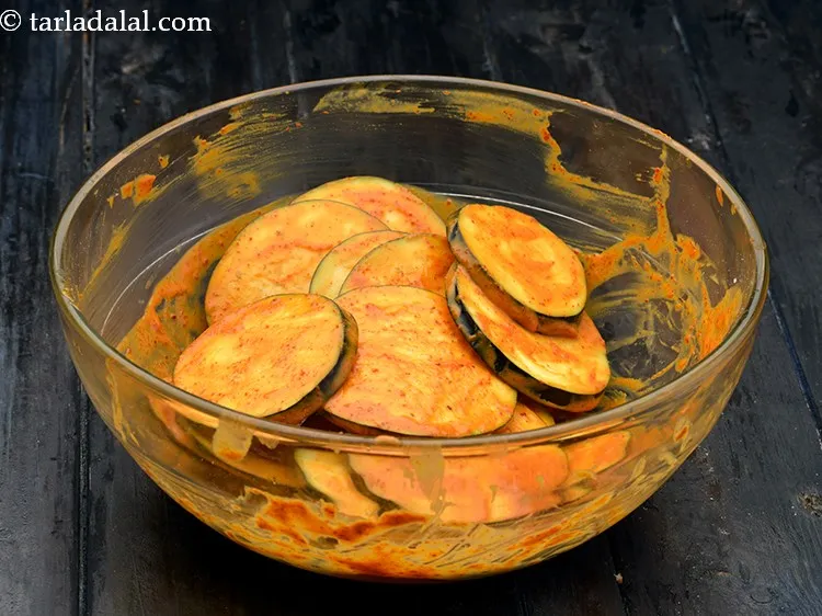 Step 9 – Mix well rubbing the spice mix with your fingers so the brinjal slices are evenly …