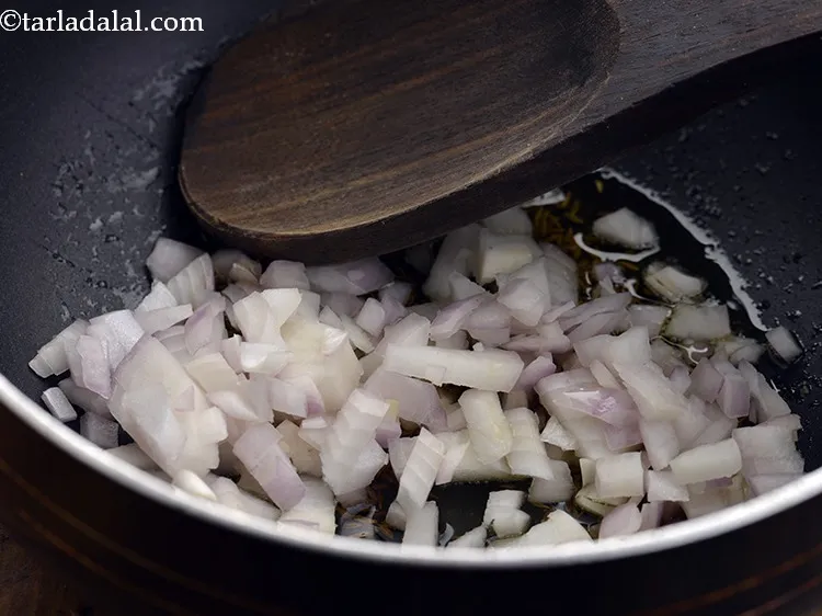 Step 8 – When the seeds crackle, add onions.