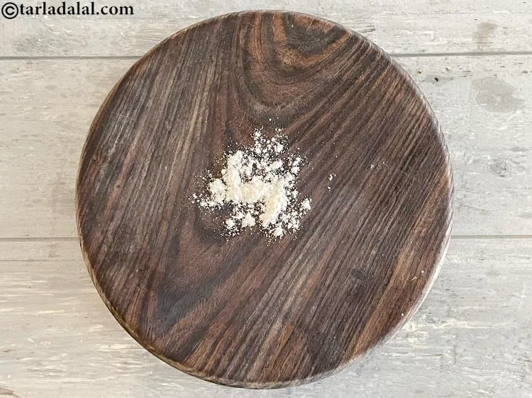 स्टेप 13 – रोलिंग की सतह पर थोड़ा सुखा आटा छिड़कें।