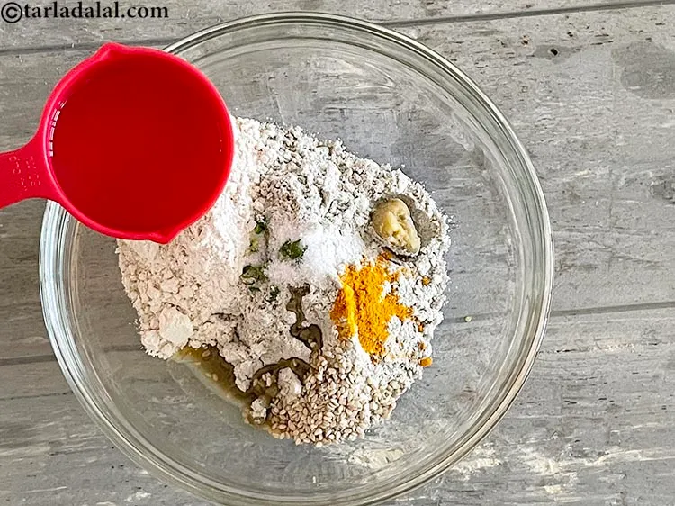 स्टेप 10 – एक सख्त आटा बनाने के लिए पर्याप्त गरम पानी डालें। …