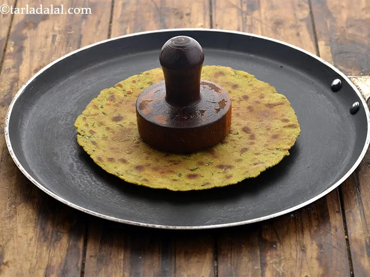 Step 19 – Continue cooking the <strong>khakhra</strong> on a slow flame, while pressing with a <strong>khakhra</strong> press or …