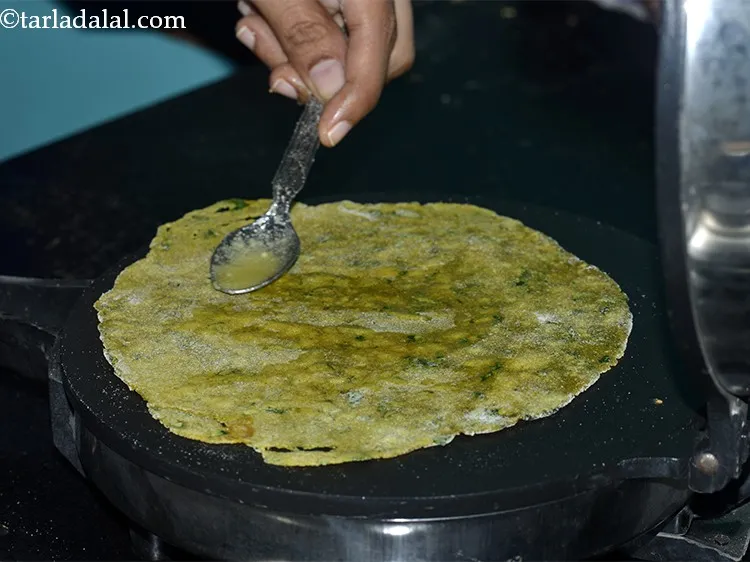Step 31 – Flip and cook again for 10 seconds apply &frac14; tsp of ghee on each side.
