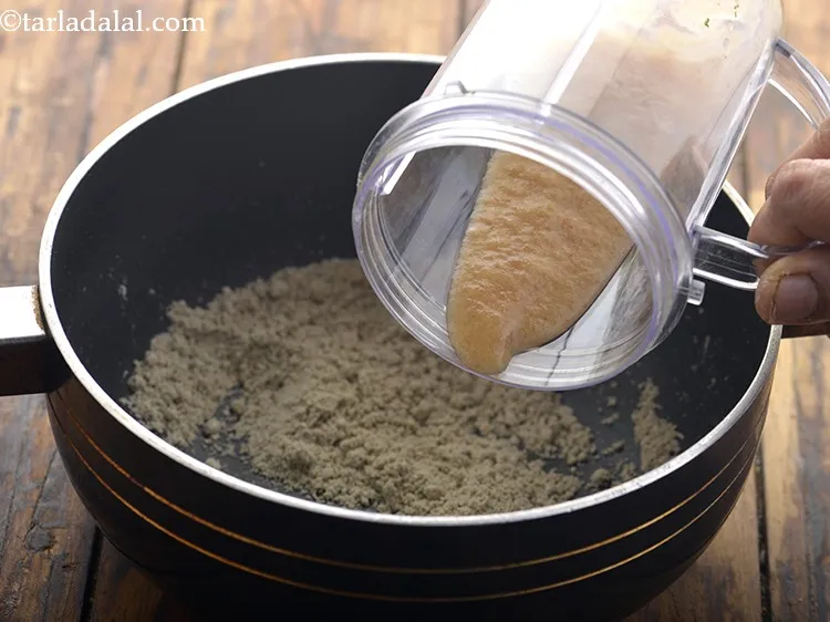 Step 13 – As the colour of the bajra flour changes to light brown, add the prepared dates …