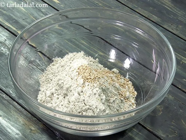 स्टेप 3 – तिल डालें। हल्के से कुचले हुए सौंफ या अजवायन को …