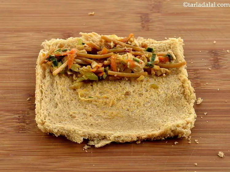 Step 25 – Spread 1 tbsp of the prepared stuffing at one end of the bread slice .