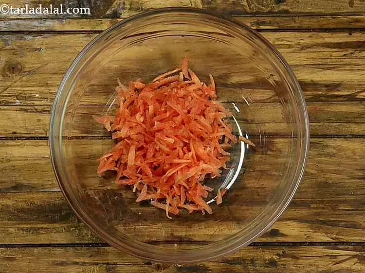 Step 4 – In a deep bowl, take thickly grated carrot.