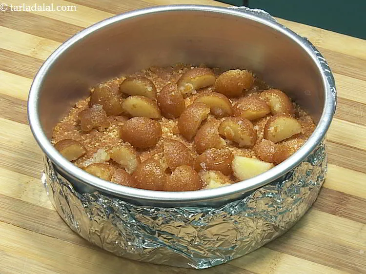 Step 17 – Put pieces of gulab jamun evenly in the base of the tin.