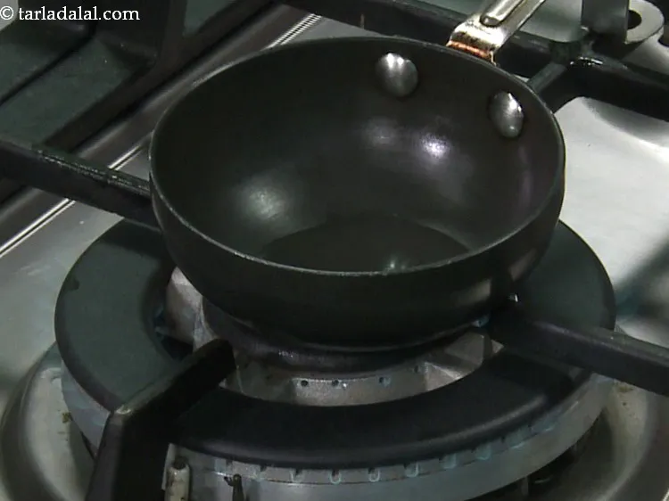 Step 17 – To temper <strong>baked poha</strong>, heat the oil in a small non-stick pan.