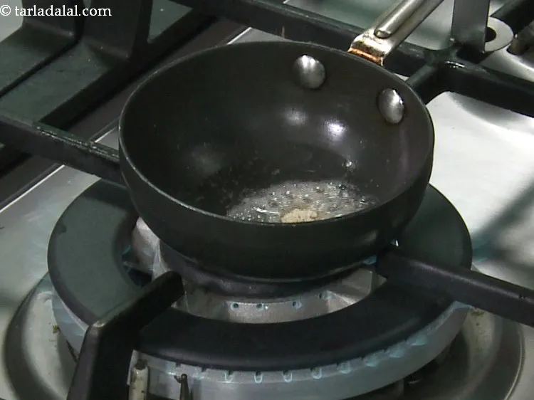 Step 19 – When the seeds crackle, add the asafoetida and mix well.