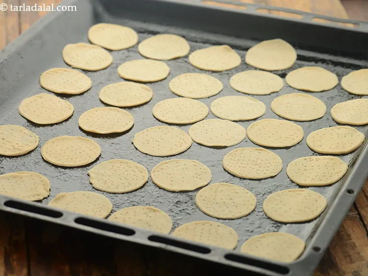 Step 14 – Arrange all the<strong> papadis</strong> on the baking tray.