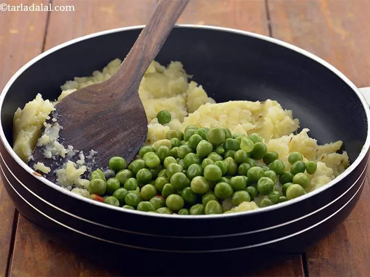 Step 19 – Add the green peas to the <strong>Baked Samosa</strong> filling. The peas are boiled and whole, …
